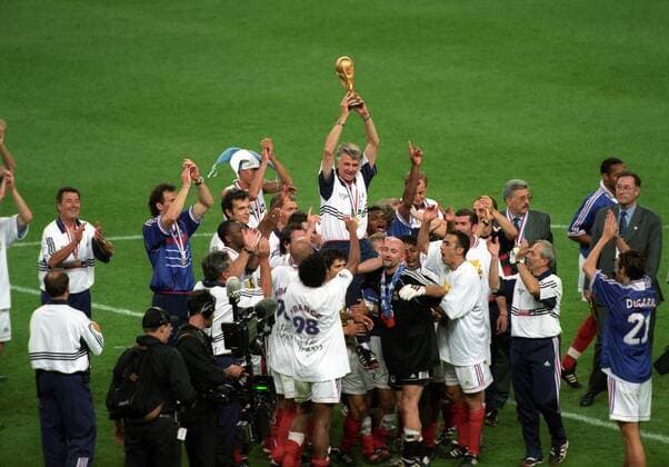 Nationaltrainer Aime Jacquet (Frankreich) mit der Weltmeistertrophäe inmitten seiner Spieler Fußball Länderspiel Herren WM 1998, Nationalteam, Finale Totale Paris Freude,