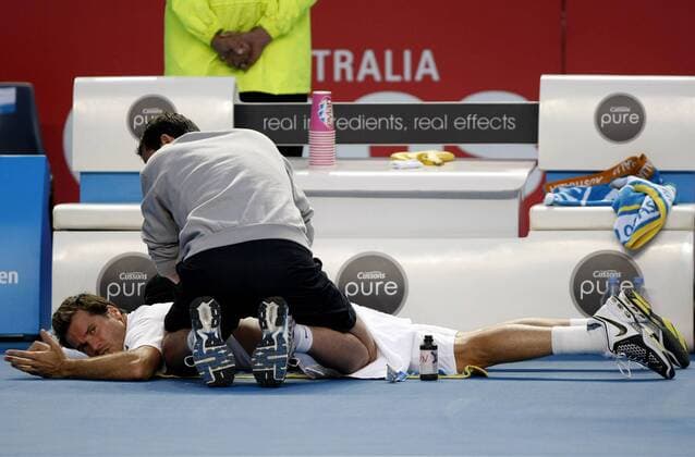Melbourne, Tommy Haas (GER) liegt auf dem Boden und wird vom Physiotherapeuten am Rücken behandelt o0 Thomas Betreuer o00 Verletzung Arzt