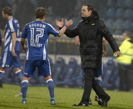 Trainer Heiko HERRLICH und Lewis HOLTBY (beide Bochum) reichen sich die Haende - VfL Bochum (blau) - Bayer 04 Leverkusen (rot) 1:1, 06.02.2010