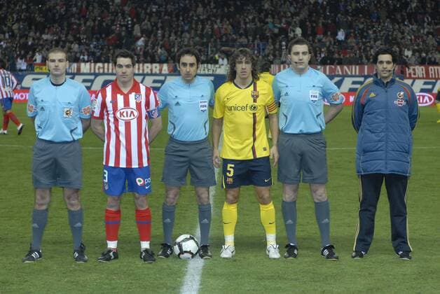 Futbol - Liga BBVA - 2009 2010 - Estadio Vicente Calderon - Atletico Madrid (rot) - FC Barcelona (gelb) - 14 02 2010 - Schiedsrichtergespann um Schiedsrichter Javier Estrada Fernandez (Mitte) mit den beiden Kapitänen Antonio Lopez (Madrid) und Carles Puyol (Barca) --- 