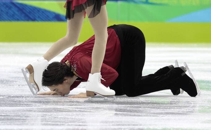 Jian Tong of China kisses the ice after performing his routine with partner Qing Pang in the Figure Skating Pairs Free program at the 2010 Winter Olympics at Pacific Coliseum in Vancouver, Canada on February 15, 2010. The pair won the silver medal in the competition.  BKX2010021574 o0 Kuss Eis Jubel, Freude