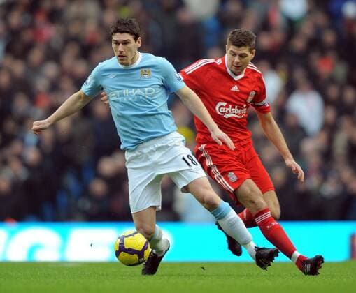 Gareth Barry of Manchester City (blue) chased by Steven Gerrard of Liverpool FC (red) Barclays Premier League Manchester City (blue) v Liverpool 21st February, 2010 EDITORIAL USE ONLY. No use with unauthorised audio, video, data, fixture lists, club league logos or live services. Online in-match use limited to 120 images, no video emulation. No use in betting, games or single club league player publications.