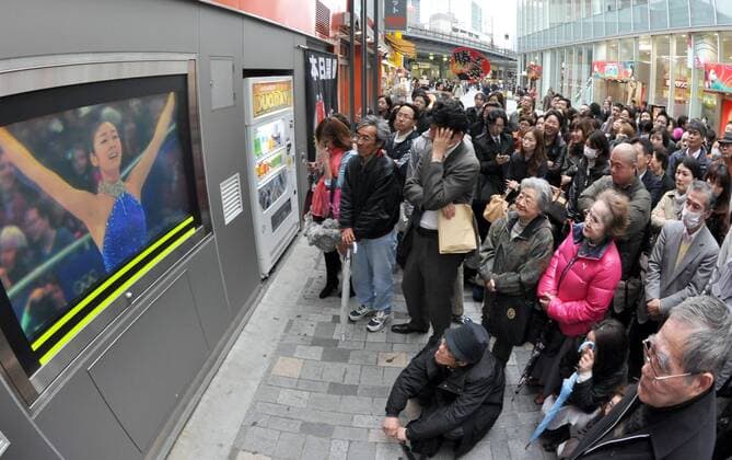 Febraury 25, 2010, Tokyo, Japan - A large crowd of gathers around a TV monitor, watching Vancouver Olympics women s figure skating free program competition in Tokyo on Wednesday, February 26, 2010. Kim Yu-na (on the screen) of South Korea won the goldmedal by scoring 228.56 points  (001041) o0 Fernseher Bildschirm Live Übertragung, , Liveübertragung