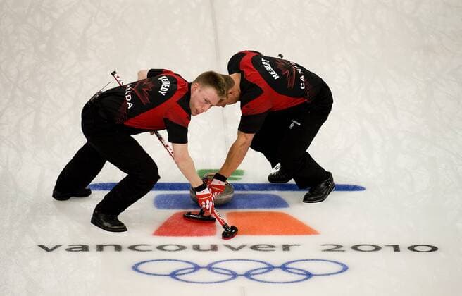 Feb. 27, 2010 - Vancouver, British Columbia, Canada - Olympics Men s Curling- Canada s Marc Kennedy (L) and Ben Hebert guide the stone down the court in Men s Curling finals at the 2010 Winter Olympic on February 27, 2010 in Vancouver, British Columbia..Canada beat Norway 6-3 and won the goldmedal. - ZUMAj89
