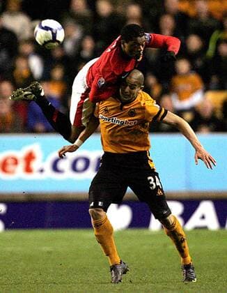 Patrice Evra of Manchester United (L) and Adiene Guedioura of Wolverhampton Wanderers leap for the ball Barclays Premier League Wolverhampton Wanderers v Manchester United 6th March, 2010 EDITORIAL USE ONLY. No use with unauthorised audio, video, data, fixture lists, club league logos or live services. Online in-match use limited to 120 images, no video emulation. No use in betting, games or single club league player publications.