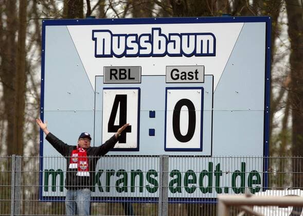 Markranstädt, Stadion am Bad, 11.04.2010, Fußball, NOFV Oberliga. Anzeigetafel mit dem Endstand von 4:0 bejubelt von einem Fan. ,