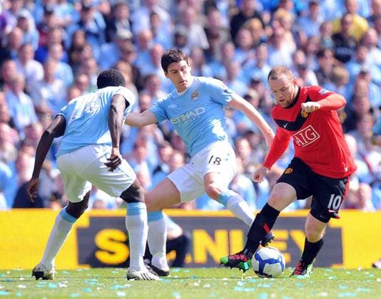 Wayne Rooney (R) of Manchester United goes past Gareth Barry (C) of Manchester City Barclays Premier League - Manchester City vs. Manchester United (ManU) 17th April, 2010 EDITORIAL USE ONLY. No use with unauthorised audio, video, data, fixture lists, club league logos or live services. Online in-match use limited to 120 images, no video emulation. No use in betting, games or single club league player publications.