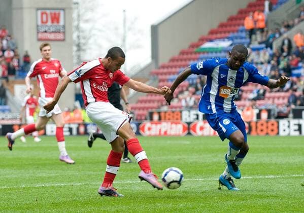 Theo Walcott of Arsenal FC London (L) shoots on goal Barclays Premier League Wigan Athletic v Arsenal 18th April, 2010 EDITORIAL USE ONLY. No use with unauthorised audio, video, data, fixture lists, club league logos or live services. Online in-match use limited to 120 images, no video emulation. No use in betting, games or single club league player publications.