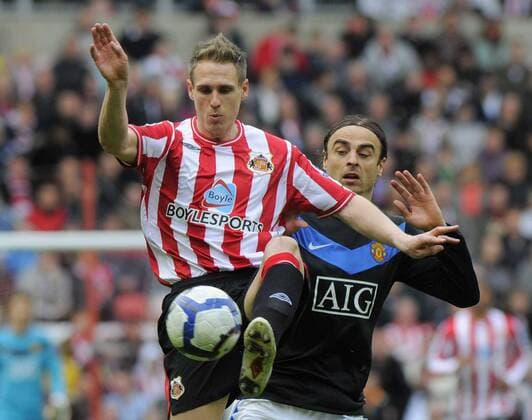 Sunderland s Matthew Kilgallon and ManU s Dimitar Berbatov, Sunderland AFC (red) - Manchester United (black), EDITORIAL USE ONLY. No use with unauthorised audio, video, data, fixture lists, club league logos or live services. Online in-match use limited to 120 images, no video emulation. No use in betting, games or single club league player publications.