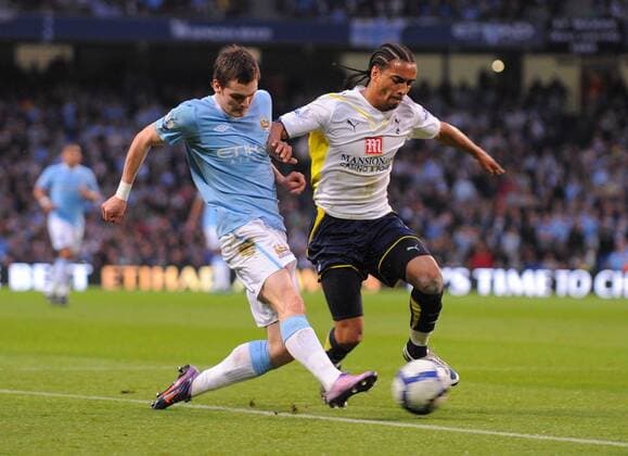 Benoit Assou-Ekotto of Tottenham tackles Adam Johnson (blue) of Manchester City Barclays Premier League Manchester City v Tottenham Hotspur 5th May, 2010 EDITORIAL USE ONLY. No use with unauthorised audio, video, data, fixture lists, club league logos or live services. Online in-match use limited to 120 images, no video emulation. No use in betting, games or single club league player publications.