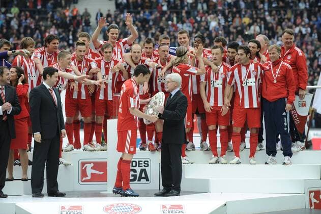 Deutscher Meister 2010 - FC Bayern München: DFL Ligapräsident Reinhard Rauball überreicht Mark van Bommel die Meisterschale, die Bayern Spieler können es kaum erwarten o0 Siegerehrung Jubel Freude Objekte Trophäe Funktionär Mannschaftsfoto Pokal Schale