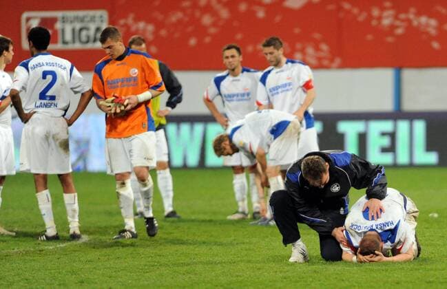 Relegationsspiel zur 2. Bundesliga, Fußball, FC Hansa Rostock - FC Ingolstadt 04, Rostock enttäuscht nach dem Abstieg, Trainer Marco Kostmann (2. v. r.) tröstet Enrico Kern, 17.05. 2010, o0 Enttäuschung