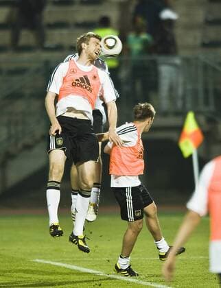Per MERTESACKER l. (GER) beim Kopfball gegen Philipp LAHM , Trainingsspiel, Öffentliches Training der deutschen Fussball Nationalmannschaft im Super Stadium in Atteridgeville am 07.06.2010.