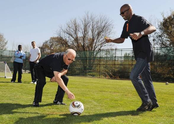 Lehrstunde: Franz BECKENBAUER (GER, links) zeigt auf dem Ball, Edwin MOSES (USA, Laureus Praesident), laeuft zum Schuss an, Laureus meets Nationalmannschaft -Kindertraining. Training der Deutschen Fussball Nationalmannschaft in Erasmia Centurion, 09.06.2010. FIFA - Fussball Weltmeisterschaft 2010 in Suedafrika