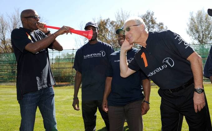 Vor Kindern und Jugendlichen des Laureus Projekt Sports for all aus Johannesburg blaest Laureus President Edwin MOSES (USA, L) die Vuvuzela. Franz BECKENBAUER (GER, R) hoert zu. Laureus meets Nationalmannschaft -Kindertraining. Training der Deutschen Fussball Nationalmannschaft in Erasmia Centurion, 09.06.2010. FIFA - Fussball Weltmeisterschaft 2010 in Suedafrika
