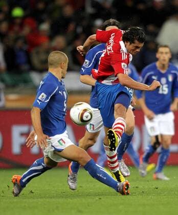 Nelson Valdez of Paraguay (front R) kicks the ball in front of Fabio Cannavaro (Italy) during the Group F first round match against Italy at 2010 FIFA World Cup at Green Point stadium in Cape Town 