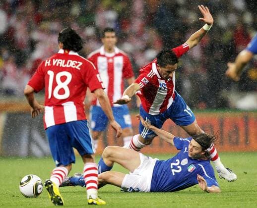 Lucas Barrios (top, R) of Paraguay is tackled by Riccardo Montolivo of Italy (bottom) during their Group F first round match at 2010 FIFA World Cup at Green Point stadium in Cape Town 