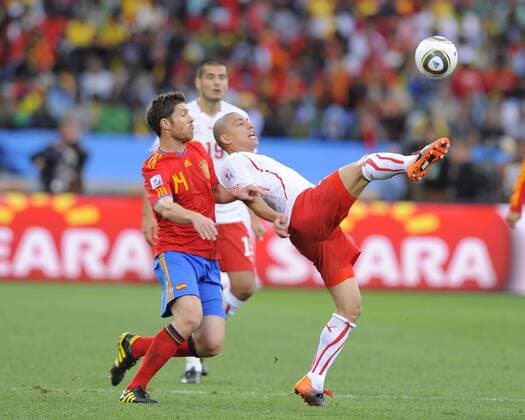 Gökhan Inler of Switzerland and Xabi Alonso of Spain - Spain (red) vs Switzerland - EDITORIAL USE ONLY. No use with unauthorised audio, video, data, fixture lists, club league logos or live services. Online in-match use limited to 120 images, no video emulation. No use in betting, games or single club league player publications.