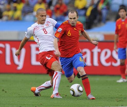 Andres Iniesta of Spain gets clear of Gökhan Inler of Switzerland - Spain (red) vs Switzerland - EDITORIAL USE ONLY. No use with unauthorised audio, video, data, fixture lists, club league logos or live services. Online in-match use limited to 120 images, no video emulation. No use in betting, games or single club league player publications.