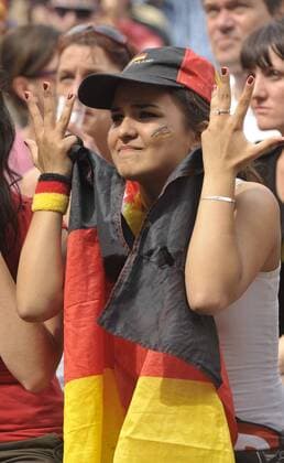 Deutsche Fußballfans verfolgen ein Vorrundenspiel Deutschlands anlässlich der Fußball-Weltmeisterschaft 2010 in der Kulturbrauerei in Berlin-Prenzlauer Berg Fußball WM - Fußballfans in Berlin o0 Frau pessimistisch Fahne, Nationalfahne Deutschlandfahne