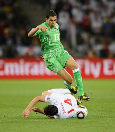 Football - 2010 FIFA World Cup - England vs. Algeria England s Gareth Barry (L) is fouled by Karim Matmour of Algeria at Green Point Stadium, Cape Town 