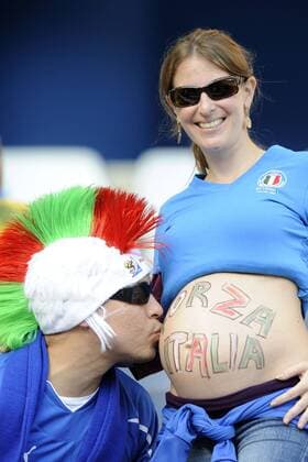 20.06.2010, Nelspruit - FIFA Weltmeisterschaft 2010 - Italienisches Fanpärchen - Der Mann küsst den schwangeren Bauch seiner Frau  o0 Fanpaar Fanpärchen Paar Pärchen Mann Frau Perücke Iro Irokese Kuss küssen Schwangerschaft