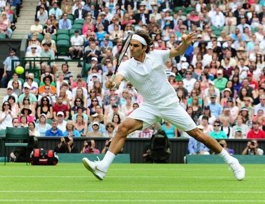 Switzerland s Roger Federer returns a shot during his first round match of men s singles in the 2010 Wimbledon Championships in London, Britain, June 21, 2010. 