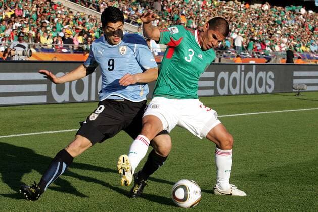22.06.2010, Rustenburg - FIFA Weltmeisterschaft 2010 - Mexiko (grün) vs Uruguay (blau) 0:1 --- Bild zeigt Luis Suarez (URU) und Carlos Salcido (MEX).  o0 Werbebande Bande Werbung Sponsor Wirtschaft Adidas