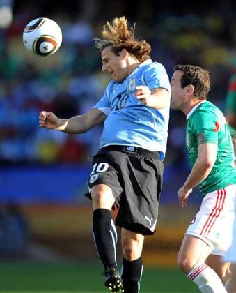 Diego Forlan of Uruguay (L) fights for the head ball with a player of Mexico during the 2010 World Cup Group A soccer match at Royal Bafokeng Stadium in Rustenburg - 