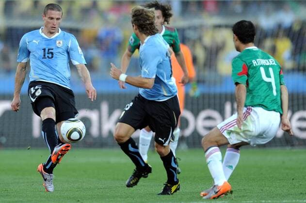 Diego Perez of Uruguay (1st L) passes the ball during the 2010 World Cup Group A soccer match against Mexico at Royal Bafokeng Stadium in Rustenburg - 