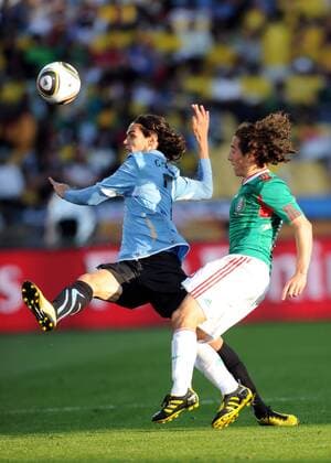 Edinson Cavani (L) of Uruguay stops the ball during the 2010 World Cup Group A soccer match against Mexico at Royal Bafokeng Stadium in Rustenburg - 