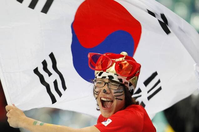 A fan of South Korea cheers with a national flag prior to the 2010 World Cup Group B at Moses Mabhida stadium in Durban, on June 22, 2010.  o0 Südkorea Fahne, Nationalfahne Gesichtsbemalung, Bemalung Freude Jubel