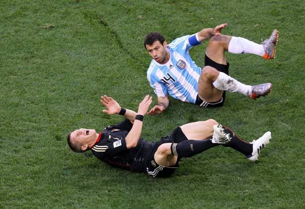Germany s Bastian Schweinsteiger (front) and Argentina s Javier Mascherano fall on the pitch during their 2010 World Cup quarterfinal soccer match at Green Point stadium in Cape Town on July 3, 2010.  o0 Foulspiel, gefoult Kampf Härte Boden Schmerz Schrei