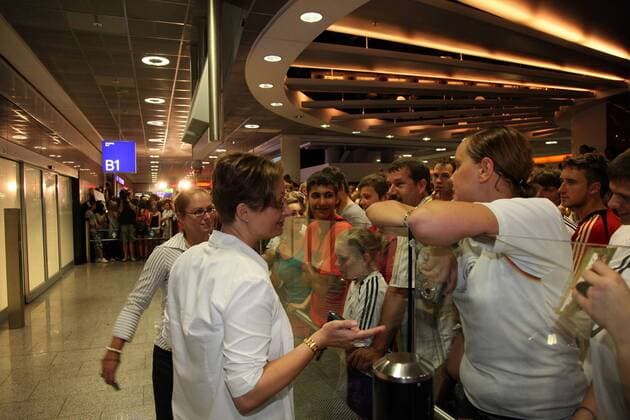 FRAPORT Mitarbeiterinnen müssen den vergeblich wartenden Fans erklären, dass ihr Team nicht kommt Fans warten am Frankfurter Flughafen auf die DFB-Elf