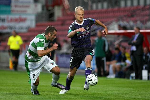Football - UEFA Champions League 3rd Qualifying Round - The New Saints FC (white green) vs. RSC Anderlecht (blue black) --- Anderlecht s Olivier Deschacht powers past New Saint s Danny Holmes at the Racecourse Ground, Wrexham 
