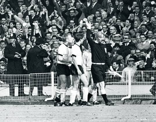 WM 1966, Endspiel, BR Deutschland vs. England 2:4 n.V. - Deutsche Spieler protestieren bei Linienrichter Tofik Bakhramov (UdSSR), der soeben das legendäre Wembleytor gegeben hat, v.li.: Karl Heinz Schnellinger, Lothar Emmerich und Wolfgang Overath o0 Tor Wembley Gestik Schiri Schiedsrichterentscheidung Geschichte Fußballgeschichte Zuschauer