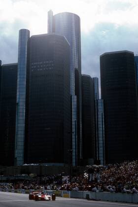John Watson (England McLaren Ford), Sieger des GP der USA, ballt jubelnd die Faust bevor er vor der Skyline von Detroit, die Ziellinie passiert  o0 Sportstätte Totale Rennstrecke Rennkurs Strecke Kurs Circuit City, Stadt, Stadtkurs, Stadtbild