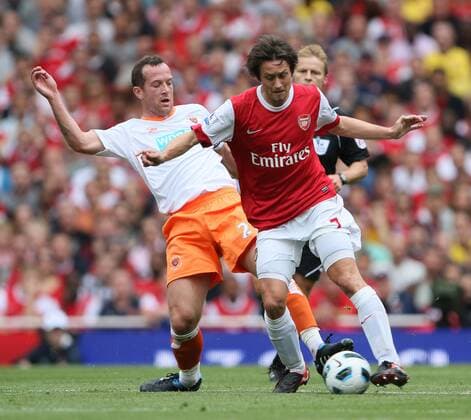 Arsenal s Tomas Rosicky tussles with Blackpool s Charlie Adam Barclays Premier League Arsenal London (red) v Blackpool FC (white) 21st August, 2010 EDITORIAL USE ONLY. No use with unauthorised audio, video, data, fixture lists, club league logos or live services. Online in-match use limited to 120 images, no video emulation. No use in betting, games or single club league player publications.