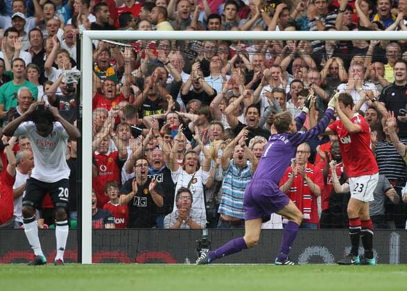 Manchester United s Edwin Van Der Sar (C) makes a superb save from Fulham s Dickson Etuhu - Barclays Premier League Fulham FC (white) v Manchester United ManU (red) 22nd August, 2010 EDITORIAL USE ONLY. No use with unauthorised audio, video, data, fixture lists, club league logos or live services. Online in-match use limited to 120 images, no video emulation. No use in betting, games or single club league player publications.