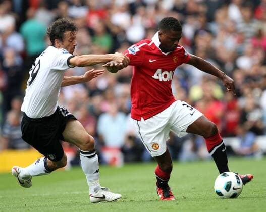 Fulham s Simon Davies tussles with Manchester United s Patrice Evra - Barclays Premier League Fulham FC (white) v Manchester United ManU (red) 22nd August, 2010 EDITORIAL USE ONLY. No use with unauthorised audio, video, data, fixture lists, club league logos or live services. Online in-match use limited to 120 images, no video emulation. No use in betting, games or single club league player publications.
