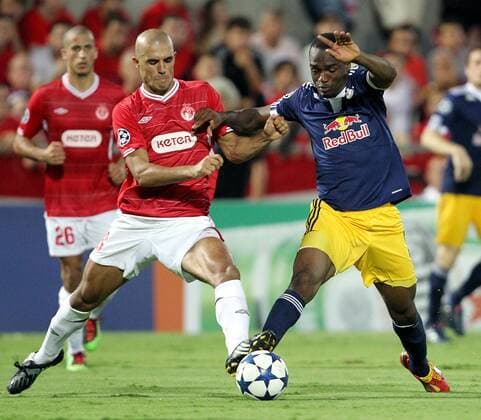 FUSSBALL - CL Play-Off, TEL AVIV,24.AUG.10 - FUSSBALL - UEFA Champions League, Play-Off, Hapoel Tel Aviv (rot) vs Red Bull Salzburg (dunkelblau). Bild zeigt Douglas da Silva (Tel Aviv) und Louis Ngwat Mahop (RBS). 