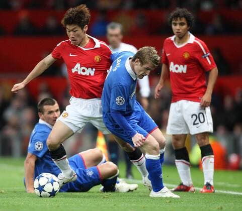 Manchester United (red) vs Glasgow Rangers (blue) - Manchester United s Ji Sung Park (2L) tackles Rangers Steven Davies (front) during the Manchester United vs Glasgow Rangers, Group C, Champions League match. Old Trafford.  101592558 1015