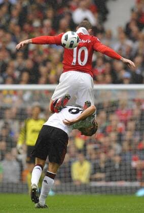Wayne Rooney (up) of Manchester United gets a lift off Christian Poulsen of Liverpool Premier League - Manchester United vs. Liverpool FC 19th September, 2010 EDITORIAL USE ONLY. No use with unauthorised audio, video, data, fixture lists, club league logos or live services. Online in-match use limited to 120 images, no video emulation. No use in betting, games or single club league player publications.
