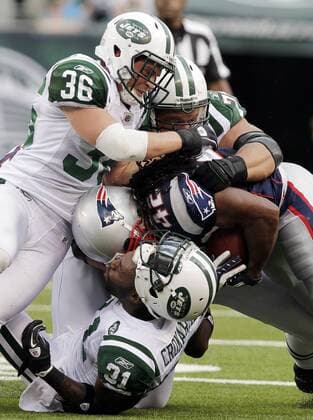 New England Patriots BenJarvus Green-Elis drives into New York Jets Antonio Cromartie as his helmet comes off in week 2 of the NFL season at New Meadowlands Stadium in East Rutherford, New Jersey on September 19, 2010.  NYP20100919110