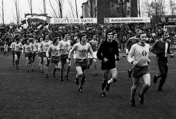 VfL Wolfsburg gegen Eintracht Braunschweig 2-0 am 10.11.1973. Einmarsch der Mannschaften, Braunschweig (hell), v.re: Wolfgang Grzyb, Torwart Bernd Franke, Franz Merkhoffer, Friedhelm Haebermann; sowie Wolfsburg (dunkel), v.re.: Torwart Dieter Grünsch, Wolfgang Matz, Wolfgang Wallek und Wolf Rüdiger Krause o0 Regionalliga Nord 1973 1974, Einmarsch, einlaufen, auflaufen, Totale