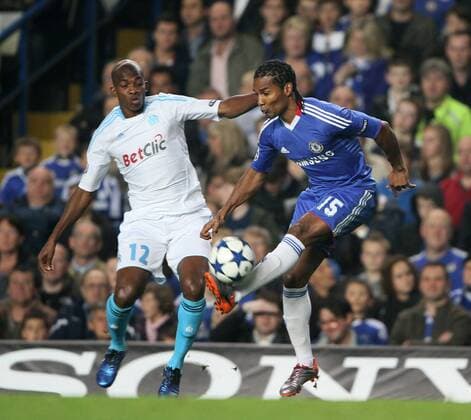 Chelsea s Florent Malouda tussles with Marseilles Charles Kabore - Champions League Group F - Chelsea FC (blue) v Olympique Marseille - 28th September, 2010 EDITORIAL USE ONLY. No use with unauthorised audio, video, data, fixture lists, club league logos or live services. Online in-match use limited to 120 images, no video emulation. No use in betting, games or single club league player publications.