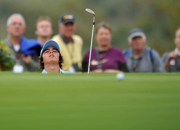 Golf - Ryder Cup 2010 - Practice Day 1: Rickie Fowler of the USA winces as his bunker shot at narrowly misses the hole at Celtic Manor, Newport 