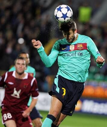 KAZAN, SEPTEMBER 29, 2010. Rubin s Sergei Kornilenko and Barca s Gerard Pique (R) seen during the Champions League Group D soccer match at Central stadium in Kazan. The match between Rubin Kazan and FC Barcelona ends in a 1-1 draw.  premiumd xint Aufmacher RE0D8DBF