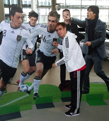 Berlin 06.10.2010 - DFB Pressekonferenz - Philipp Lahm (GER) unterschreibt ein lebensgrosses Foto von ihm selbst, daneben Pappfiguren von v.li.: Mesut özil, Mario Gomez, Teammanager Oliver Bierhoff und Bundestrainer Joachim Löw (GER)