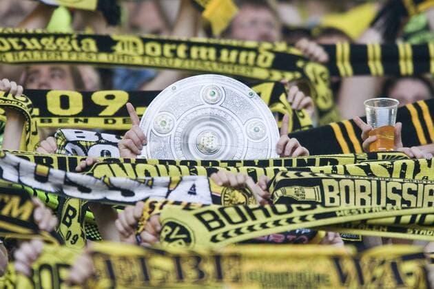 Deutsche Meisterschale, Meisterschaftsschale wird zwischen Fanschals, Schals von Fans, Anhaenger n von Borussia Dortmund hochgehalten; 1. Fussball Bundesliga BVB Borussia Dortmund o0 Attrappe Imitat Nachbildung Schal, Fanschal Objekte Fans Zuschauer